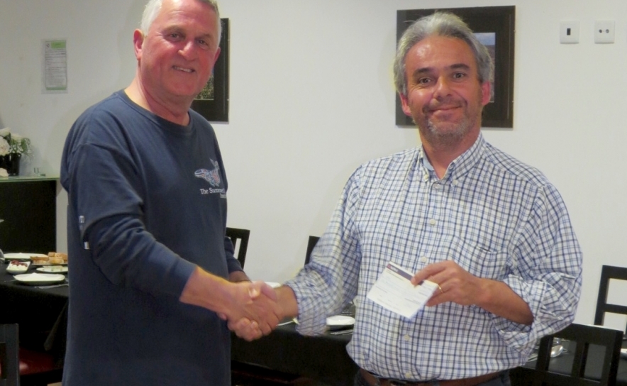 O guia da Honeyguide Rob Macklin (esquerda) dá o cheque Wildlife Charitable Trust a Domingos Leitão, guia do grupo e membro da SPEA, no valor de €1000 (£763).